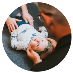 A chiropractor gently adjusting a baby, showing pediatric chiropractic care.